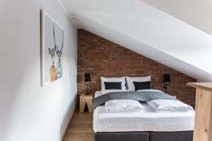 a bedroom with a bed and a brick wall at Kandahar Lodge in Garmisch-Partenkirchen