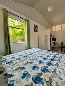 a bedroom with a bed and a window and a refrigerator at Villas Cozy Sloth in Puerto Viejo