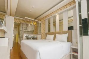 a bedroom with a large white bed in a room at Quintessa Room at Candiland Apartment in Jomblang
