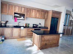 a kitchen with wooden cabinets and a black counter top at Camly Chic Villa in Da Lat