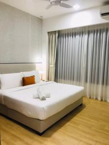 a bedroom with a large white bed in front of a window at KLCC Agile Sky villa Residences in Kuala Lumpur +127 photos