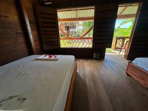 a bedroom with a bed and a large window at la bamba, cabaña barracuda in Nuquí +34 photos