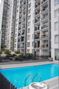 a swimming pool in front of a large apartment building at Auroras apartment 2 habitaciones in Santiago