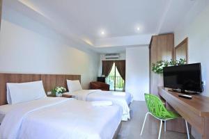 Ban Si ThanにあるGasser Park & Residenceのベッド2台とテレビがあるホテルの部屋