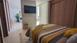a bedroom with a bed and a flat screen tv at Your Perfect Getaway in Vallarta, Pool & Balcony in Nuevo Vallarta +21 photos