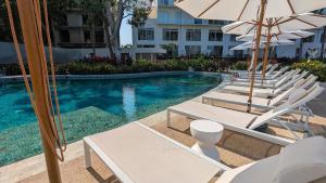 a group of chairs and umbrellas next to a swimming pool at Your Perfect Getaway in Vallarta, Pool & Balcony in Nuevo Vallarta