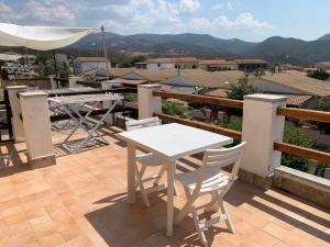 a white table and chairs on a patio with a view at Апартаменты с великолепным видом на горы in Viddalba