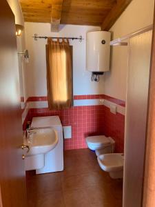 a bathroom with two sinks and a toilet at Апартаменты с великолепным видом на горы in Viddalba