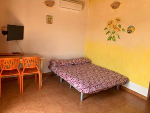 a room with two beds and a table and a desk at Апартаменты с великолепным видом на горы in Viddalba