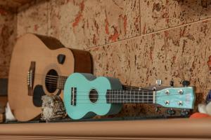 a guitar on a wall with a bird next to it at Hill Side B&B in Yuchi