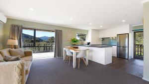 una cucina e un soggiorno con un tavolo e un divano di Tepuia Cottage - Havelock Holiday Home a Picton