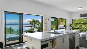 an open kitchen with a view of the ocean at Pukawa Bliss - Pukawa Holiday Home in Kuratau