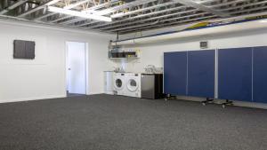 a laundry room with a washing machine and blue cabinets at Pukawa Bliss - Pukawa Holiday Home in Kuratau