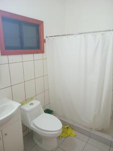 a bathroom with a toilet and a shower curtain at Descanso llafenco in Minetué +2 photos