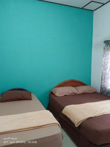 En eller flere senge i et værelse på EMBUN 2 LANGKAWI HOMESTAY