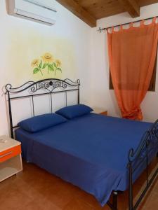 a bedroom with a blue bed and a window at Апартаменты с великолепным видом на горы in Viddalba