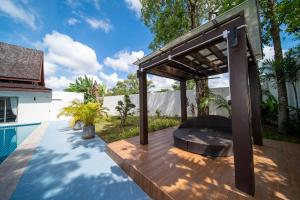 pérgola sobre una terraza de madera junto a la piscina en Bang Tao 6-bedroom large private pool modern Balinese style leisure holiday villa BBQ family group the park, en Laguna Phuket
