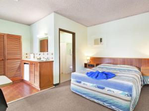 クーマにあるAlkira Motelの大きなベッドとバスルームのある寝室