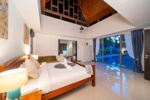 a bedroom with a bed and a living room at Bang Tao 6-bedroom large private pool modern Balinese style leisure holiday villa BBQ family group the park in Laguna Phuket +150 photos