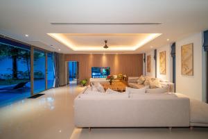 a living room with a white couch and a table at Bang Tao 6-bedroom large private pool modern Balinese style leisure holiday villa BBQ family group the park in Laguna Phuket