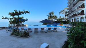 ein Resort mit Pool, Stühlen und dem Meer in der Unterkunft Studio on the beach and beautiful sea view in Puerto Vallarta