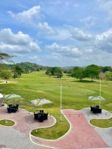 un parco con tavoli e ombrelloni in un campo di Elegante apartamento con Golf, Restaurantes y Spa a ArraijÃ¡n