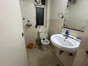 a bathroom with a sink and a toilet and a mirror at Perfect Apartment Stay in Gurgaon +14 photos