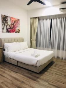 a bedroom with a bed with white sheets and a window at KLCC Agile Sky villa Residences in Kuala Lumpur