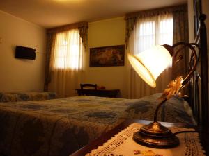 シエナにあるB&B Casale Virgiliのベッドとテーブルの上にランプが置かれた寝室