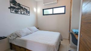 una piccola camera da letto con un letto e una finestra di Cozy studio steps from the beach and downtown a Puerto Vallarta