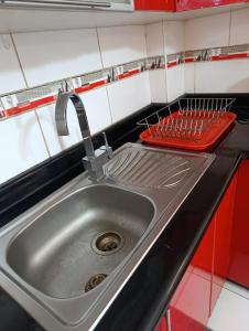 eine Küchenspüle mit einem roten Sieb daneben in der Unterkunft depahuarazhermoso in Huaraz