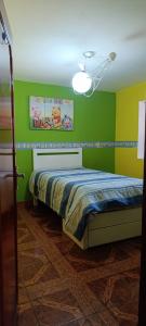 ein Schlafzimmer mit grünen und gelben Wänden und einem Bett in der Unterkunft depahuarazhermoso in Huaraz