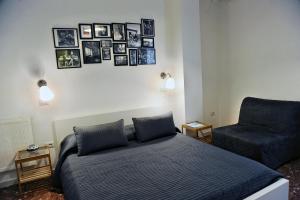 Un dormitorio con una cama y una silla y cuadros en la pared. en Casa Castagna, en Salerno