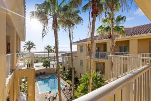 un balcon d'appartement avec des palmiers et une piscine dans l'établissement cozy & spacious condo 10min walk to beach, à South Padre Island