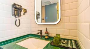ein Badezimmer mit einem Waschbecken mit einem Telefon und einem Spiegel in der Unterkunft Premier City Comfort Hotel Yangzhou Shouxi Lake West Gate Weiyang Road Siji Garden in Yangzhou + 180 Fotos