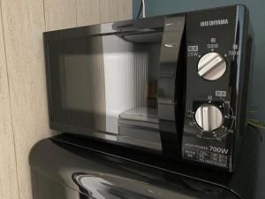 a microwave oven sitting on top of a appliance at NNS121 名古屋駅エリア貸し切りアパート 観光にもビジネスにも便利 TypeA in Nagoya