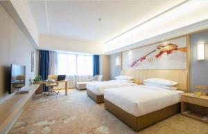a hotel room with two beds and a television at Vienna Hotel Guangxi Liuzhou Sanjiang Gulou Niaochao Passenger Station in Sanjiang +183 photos