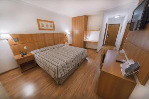 um quarto de hotel com uma cama e uma secretária em Hotel Plaza Mayor em Santo André
