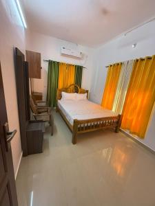 ein Schlafzimmer mit einem Bett und einem Stuhl darin in der Unterkunft Soul Shore, Varkala in Varkala + 13 Fotos