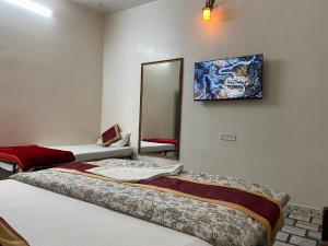 a room with two beds and a mirror at Hotel Vacation in Jaipur +66 photos