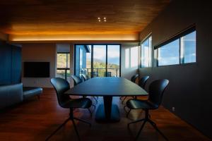 jadalnia ze stołem, krzesłami i oknami w obiekcie Awaji-shima C-Side Marine Terrace - Vacation STAY 88860v w mieście Minamiawaji