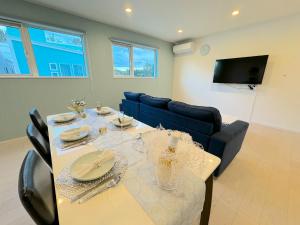jadalnia ze stołem i niebieską kanapą w obiekcie Grandioso Okinawa Villa Kin 2 - Vacation STAY 90150v w mieście Yaka