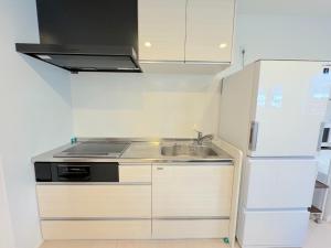 małą kuchnię ze zlewem i lodówką w obiekcie Grandioso Okinawa Villa Kin 2 - Vacation STAY 90150v w mieście Yaka
