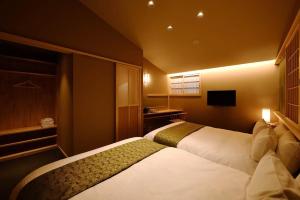 a hotel room with two beds and a television at Kyoyado Heianshiki - Vacation STAY 00358v in Kyoto