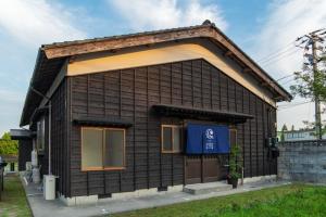 ein kleines Haus mit blauem Schild drauf in der Unterkunft guesthouse UZU Sado - Vacation STAY 90684v in Sado