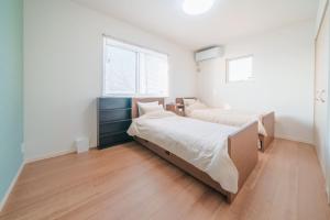 a bedroom with two beds and a window at Ryushima Ocean View Besso - Vacation STAY 13427 in Minamiboso