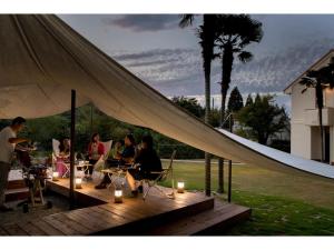 a group of people sitting on a deck under a tent at Glamp House DAISEN Garden - Vacation STAY 97255v in Yonago