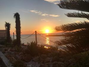 a sunset on the beach with palm trees at SunSet Villa - Vacation STAY 52994v in Nagaoka +5 photos