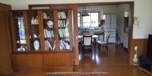 a dining room and kitchen with a dining table and bookshelves at Minami Aso Guest House Hana hana - Vacation STAY 13316 in Takamori