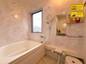 a bathroom with a tub and a toilet and a window at Nekoana Glamping - Vacation STAY 39635v in Fujikawaguchiko +16 photos